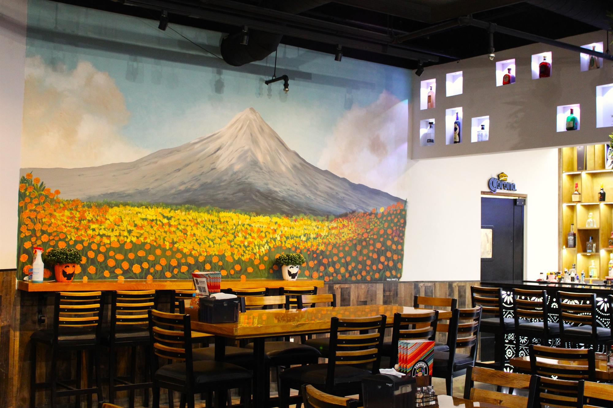 The dining room with a mural of Popocatépetl over a field of marigolds